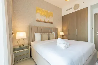 a bedroom with a large white bed and two lamps at Apartment with Stunning Canal Views, Just Minutes from Dubai Mall and Burj Khalifa - 17 Icon Bay, Dubai Creek Harbour by Deluxe Holiday Homes in Dubai