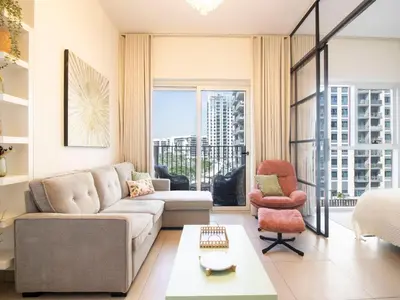a living room with a couch and a chair at Modern & Stylish Stay in 1BR Socio Dubai Hills in Dubai