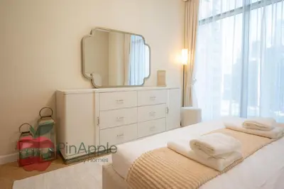 a bedroom with a bed with a dresser and a mirror at Brand New with Burj Khalifa View in Dubai