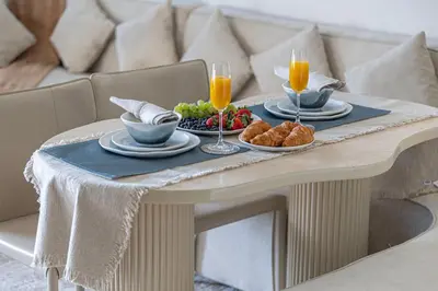 a table with two plates of food and two glasses of orange juice at Deluxe Binghatti Suites by Hostiva - Burj View in Dubai