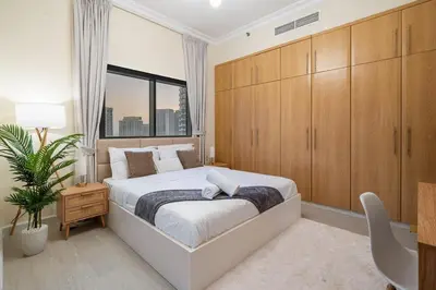 a bedroom with a large bed with wooden cabinets at Entire Apartment in Dubai Marina in Dubai