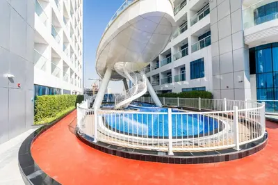a spiral staircase leading to a building with a pool at Limited Time l Private Pool I Elegance l Prime Location in Dubai