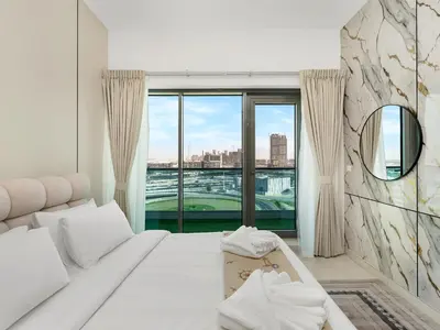 a bedroom with a white bed and a large window at Stylish 1BR Near Burj Khalifa with Rooftop Pool, City Views, Free Parking in Dubai