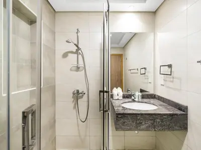 a bathroom with a sink and a shower at Stylish 1BR Near Burj Khalifa with Rooftop Pool, City Views, Free Parking in Dubai