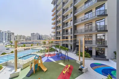 an apartment complex with a playground and a pool at Bright Studio Retreat in Floarea Residence Arjan in Dubai