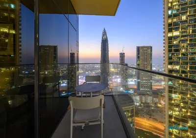 a table and two chairs on a balcony with a city skyline at FULL Burj Khalifa View Luxe 3BR in Address Opera in Dubai