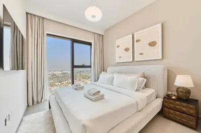 a white bedroom with a bed and a window at Modern 1BR Near Dubai Mall in Downtown Views II in Dubai