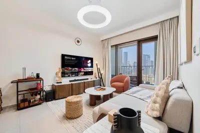 a living room with a couch and a tv at Modern 1BR Near Dubai Mall in Downtown Views II in Dubai