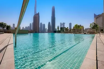 a swimming pool with a city skyline in the background at Modern 1BR Near Dubai Mall in Downtown Views II in Dubai