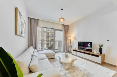 a living room with a couch and a tv at Your Dubai Hills Retreat 1BR in Park Heights 2 in Dubai