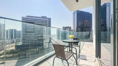 a balcony with a table and chairs and a view of a city at Modern & Cozy 1BR in Business Bay with Pool View - 10AB05 in Dubai
