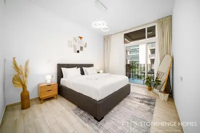 a bedroom with a bed and a large window at Cozy 1BR in Belgravia , JVC, Pool View, 20 Min from Downtown Dubai in Dubai