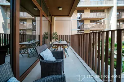 a balcony with chairs and tables on a building at Cozy 1BR in Belgravia , JVC, Pool View, 20 Min from Downtown Dubai in Dubai