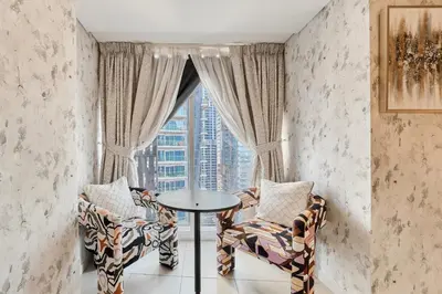 a room with two chairs and a table in front of a window at Twisting Tower Stay a Chic 2BR in Cayan Tower in Dubai