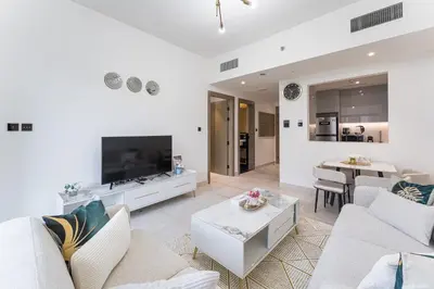 a living room with white furniture and a flat screen tv at HAVN - Spacious One Bedroom in Binghatti Creek in Dubai
