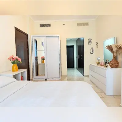 a bedroom with a large white bed and a bathroom at Cozy apartment in Dubai Marina - Torch Tower in Dubai