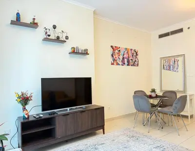 a living room with a flat screen tv and a table at Cozy apartment in Dubai Marina - Torch Tower in Dubai