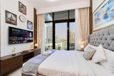 a bedroom with a large bed and a large window at Bright & Cozy Studio in Vibrant Azizi Riviera in Dubai