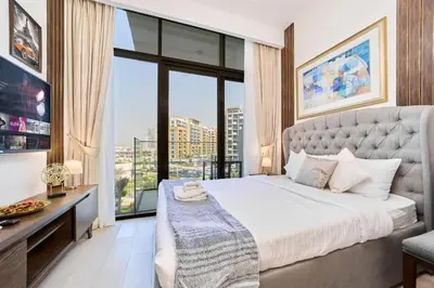a bedroom with a large bed and a large window at Bright & Cozy Studio in Vibrant Azizi Riviera in Dubai
