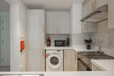 a kitchen with a washer and a stove and a washing machine at Elegant One-Bedroom Sea View Retreat on Palm West in Dubai