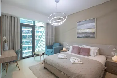 a bedroom with a bed and a blue chair at Elegant One-Bedroom Sea View Retreat on Palm West in Dubai