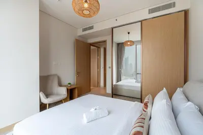 a bedroom with a white bed and a couch at HAVN - 2 Bed Burj Khalifa View, Access Dubai Mall in Dubai