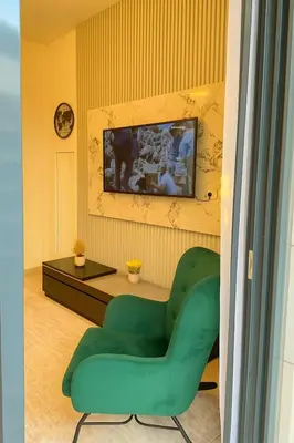 a living room with a green chair and a table at Azizi in Dubai
