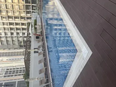 a large swimming pool on the side of a building at Azizi in Dubai