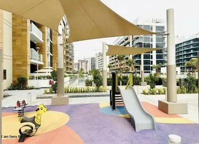a playground in a city with a building at Azizi in Dubai