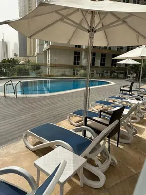 a group of chairs and umbrellas next to a pool at Fabulous 1 bed apartment within walking distance to Dubai mail and Burj Khalifa in Dubai