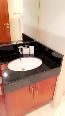 a bathroom counter with a white sink in it at Cozy private master bedroom for solo female in shared home in Dubai