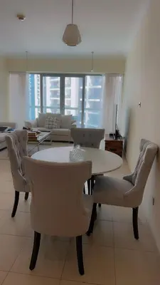 a living room with a dining room table and chairs at Cozy private master bedroom for solo female in shared home in Dubai