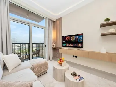 a living room with a couch and a tv at Stylish 1-Bedroom in Collective 2 - Dubai Hills in Dubai