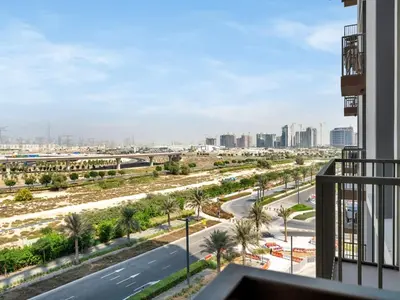 a view of a street with palm trees and a city at Stylish 1-Bedroom in Collective 2 - Dubai Hills in Dubai