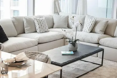 a living room with a white couch and a coffee table at Burj Khalifa View From The Infinity Pool 2BR at Downtown Dubai in Dubai