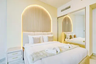a bedroom with two beds and a large mirror at PVH - Canal Frontage 1BR - Millennium Binghatti in Dubai