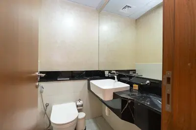 a bathroom with a white toilet and a sink at PVH - Canal Frontage 1BR - Millennium Binghatti in Dubai