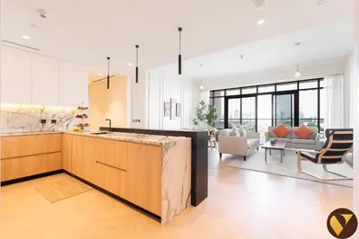 an open kitchen and living room with a couch at Vogue Emirates Hills, Vida The Hills Residence near Marina and JBR, Three Bedroom Apartment with Balcony and Golf Club View, Access to all Amenities in Dubai