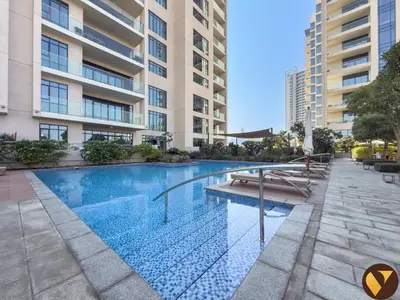 a swimming pool in front of a building at Vogue Emirates Hills, Vida The Hills Residence near Marina and JBR, Three Bedroom Apartment with Balcony and Golf Club View, Access to all Amenities in Dubai