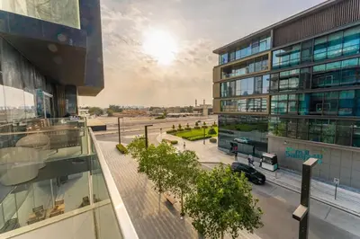 a view of a building and a street with a car at Chic 2Bedroom And Maids Room Apartment Mins from Dubai Mall in Dubai