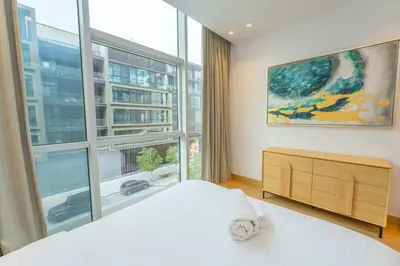 a bedroom with a bed and a large window at Chic 2Bedroom And Maids Room Apartment Mins from Dubai Mall in Dubai
