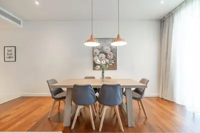 a dining room with a wooden table and chairs at Spacious Two Bedroom with Maids room Near City Mall in Dubai