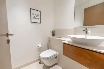 a white bathroom with a sink and a toilet at Spacious Two Bedroom with Maids room Near City Mall in Dubai