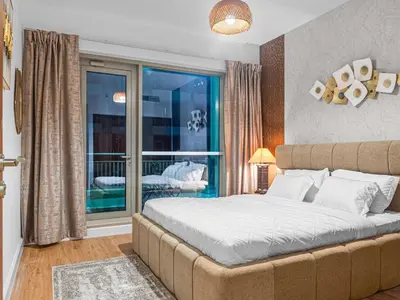a bedroom with a large bed and a balcony at Cozy 1BR Downtown Burj View in Dubai