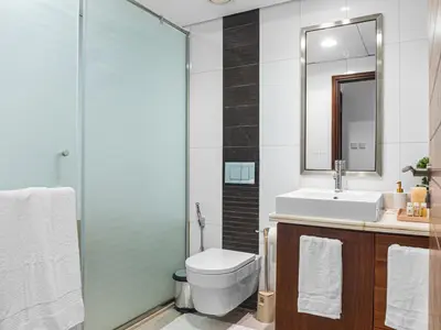 a bathroom with a toilet and a sink and a mirror at Cozy 1BR Downtown Burj View in Dubai