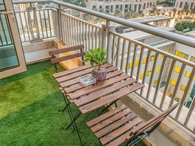 a wooden bench sitting on top of a balcony at Cozy 1BR Downtown Burj View in Dubai