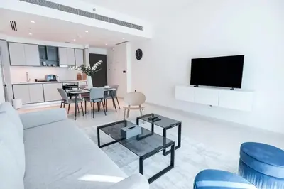 a white living room with a couch and a table at Elegant 1BR at Sunrise Bay with Stunning Palm View in Dubai