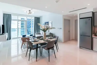 a dining room and living room with a table and chairs at Elegant 1BR at Sunrise Bay with Stunning Palm View in Dubai