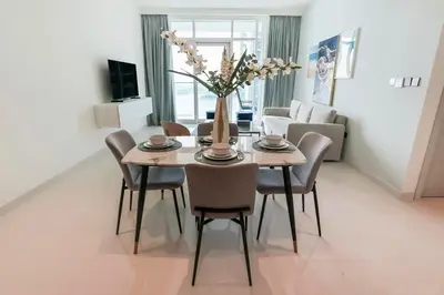 a dining room with a table and chairs at Elegant 1BR at Sunrise Bay with Stunning Palm View in Dubai
