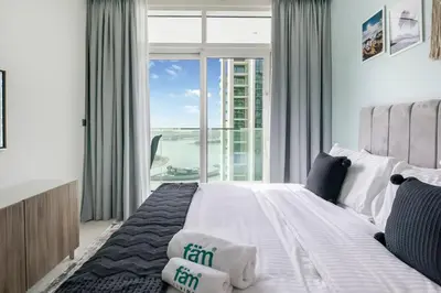 a bedroom with a large bed with a large window at Elegant 1BR at Sunrise Bay with Stunning Palm View in Dubai